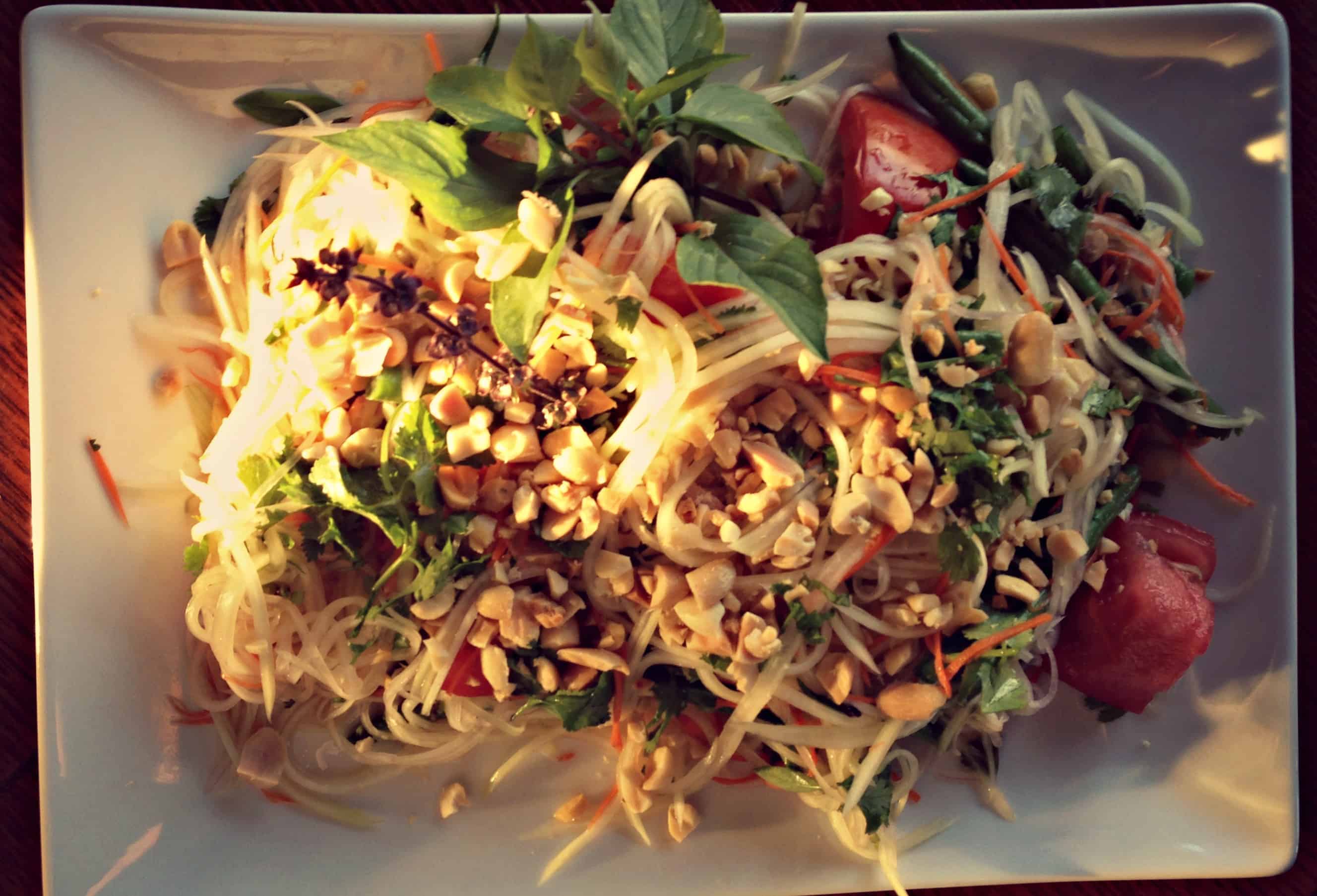 A plate of pasta topped with grilled snapper.
