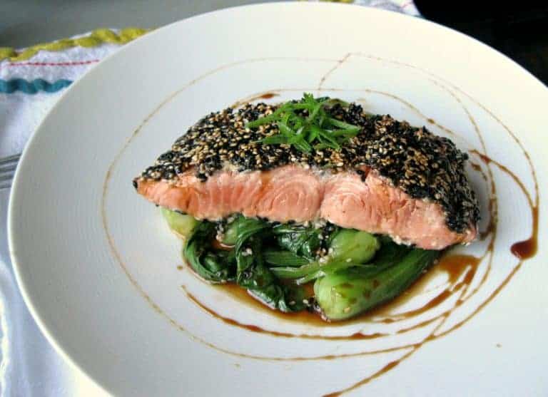 Sesame crusted salmon fillet on top of mini baby bok choy.