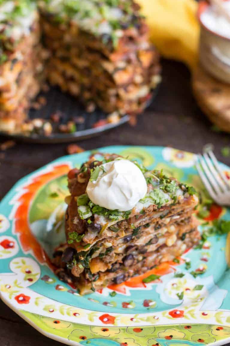 Top view of a slice of taco cake on a dinner plate.