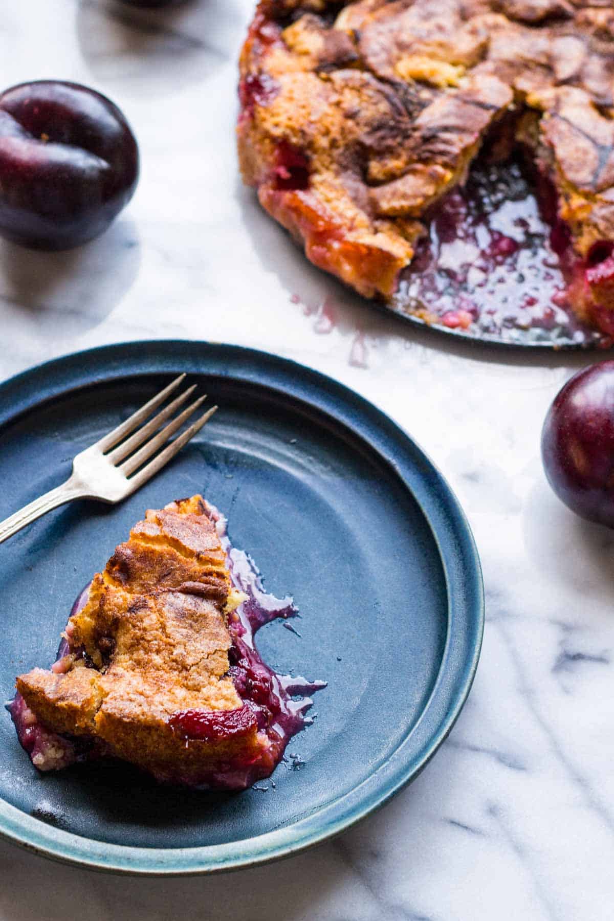 A piece of plum torte on a blue plate