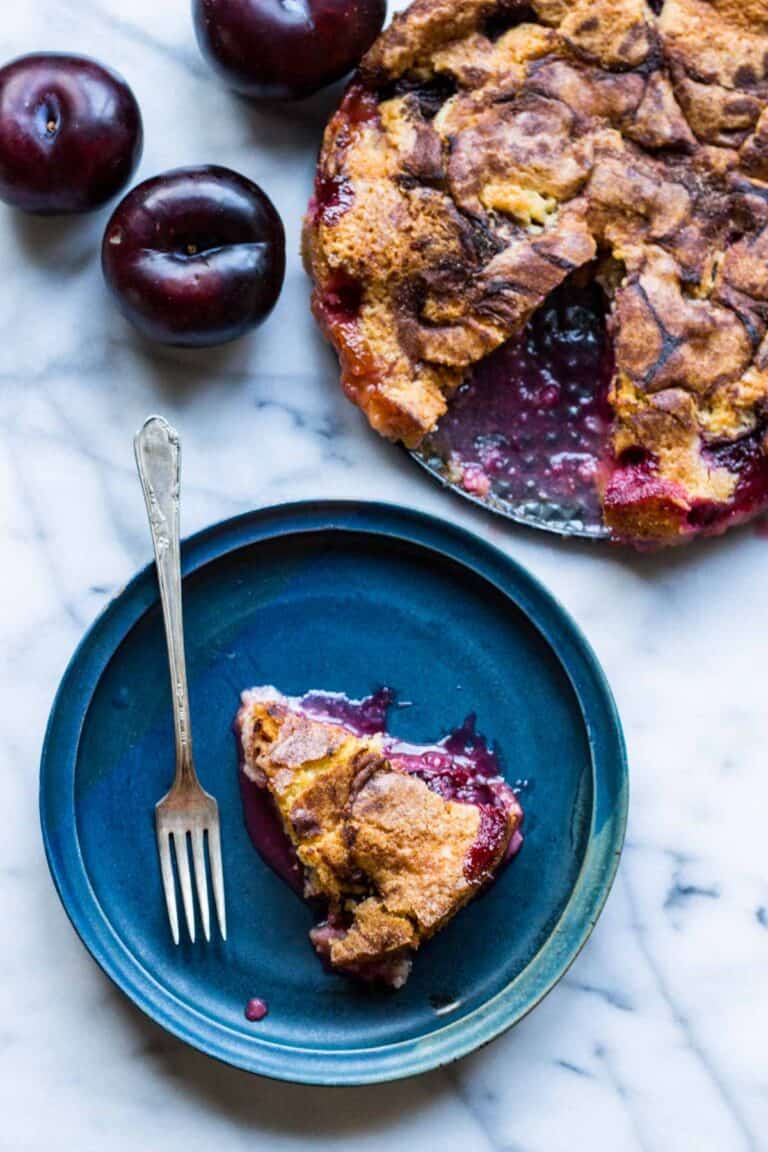 A blue plate with a piece of plum torte and a fork.