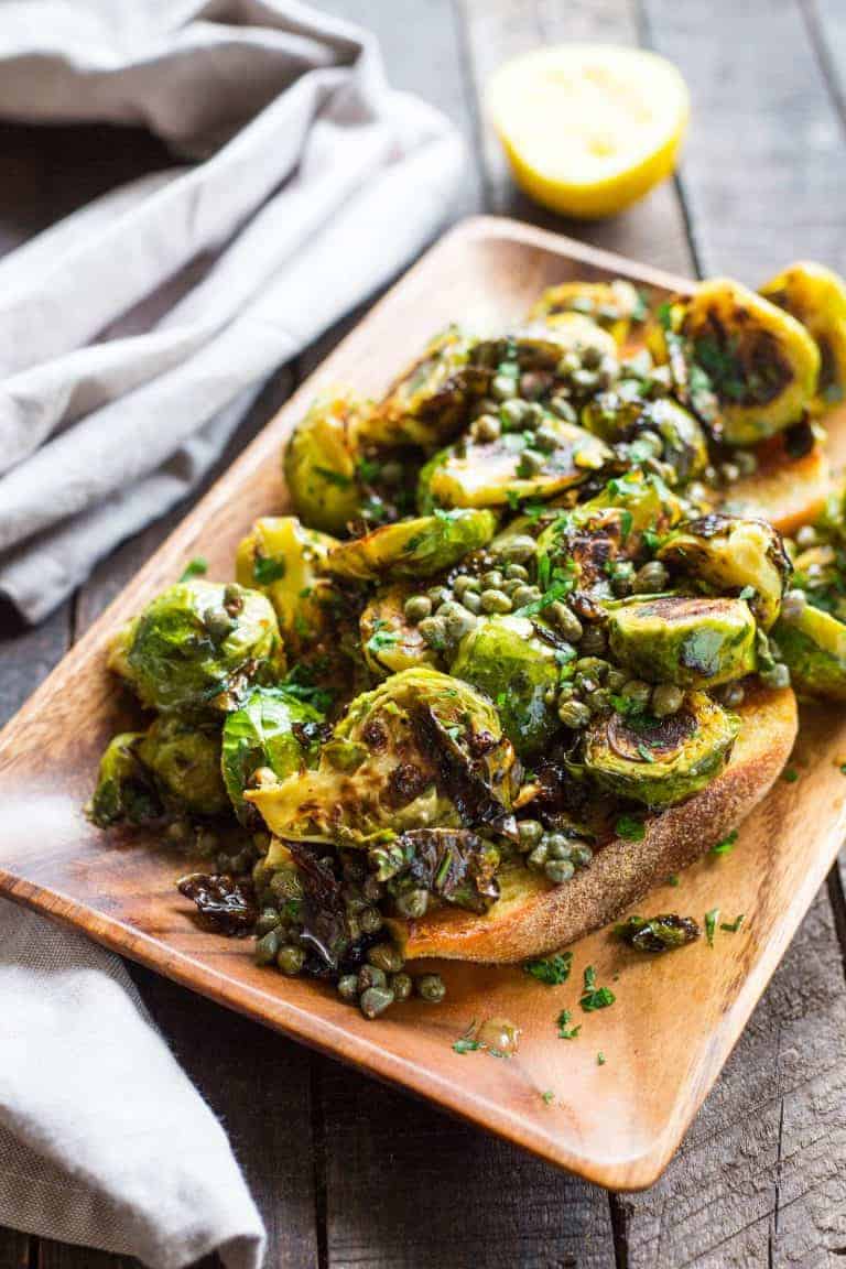 A wood platter of Brussels sprouts with anchovy caper butter.