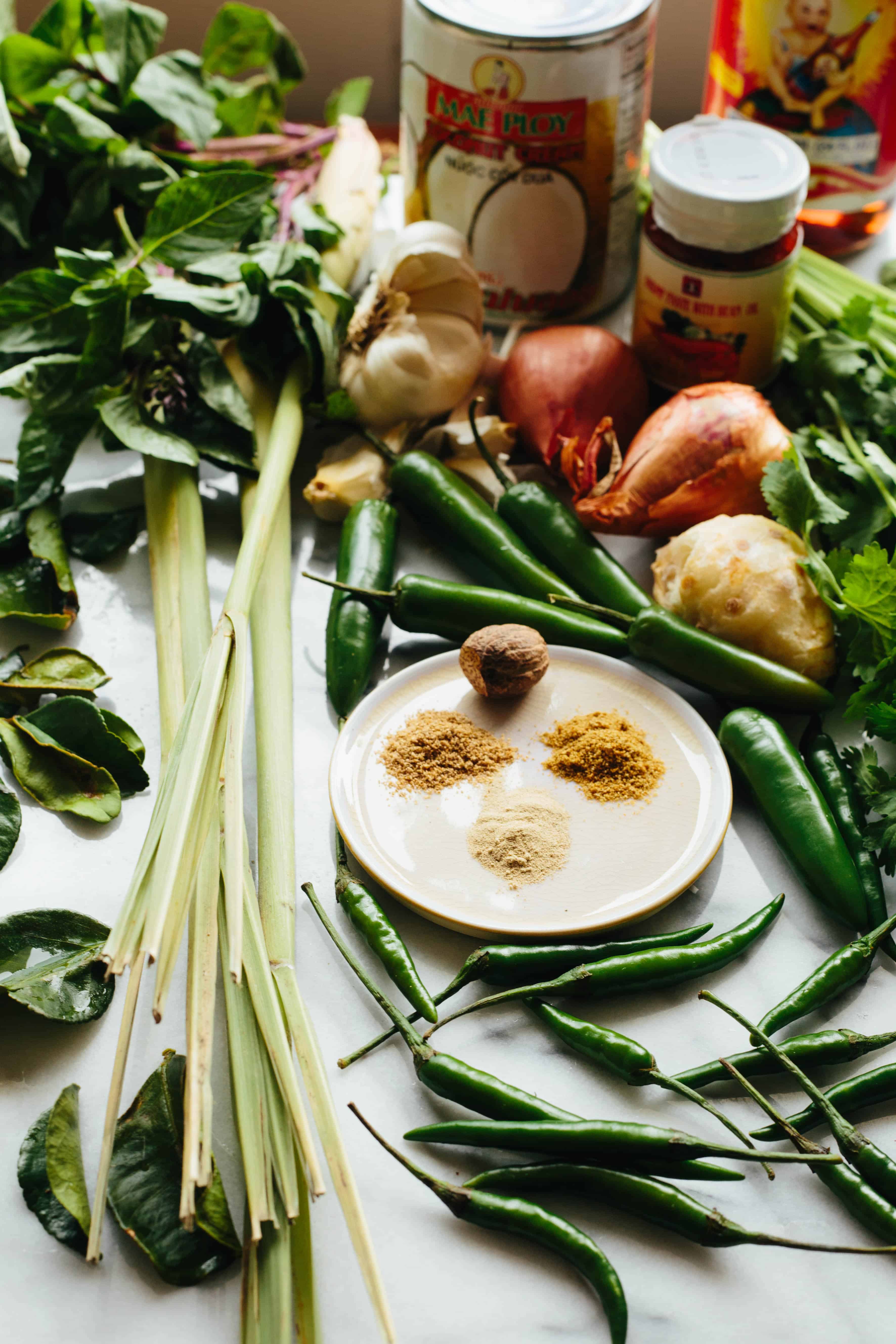 Lemongrass, onions, herbs, peppers, and seasonings laid out to be made into curry.