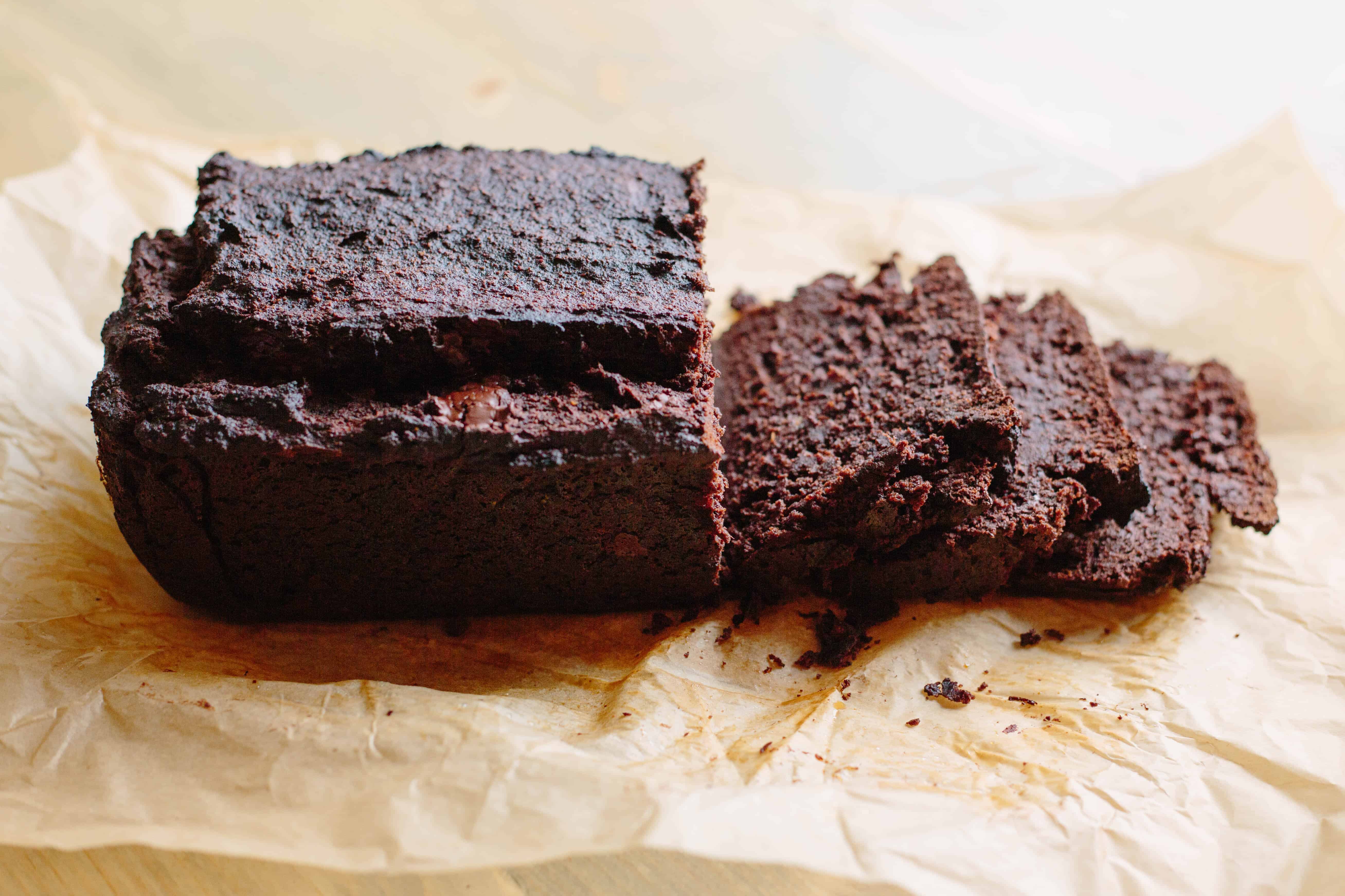 Side view of Paleo double chocolate banana bread on brown parchment paper.