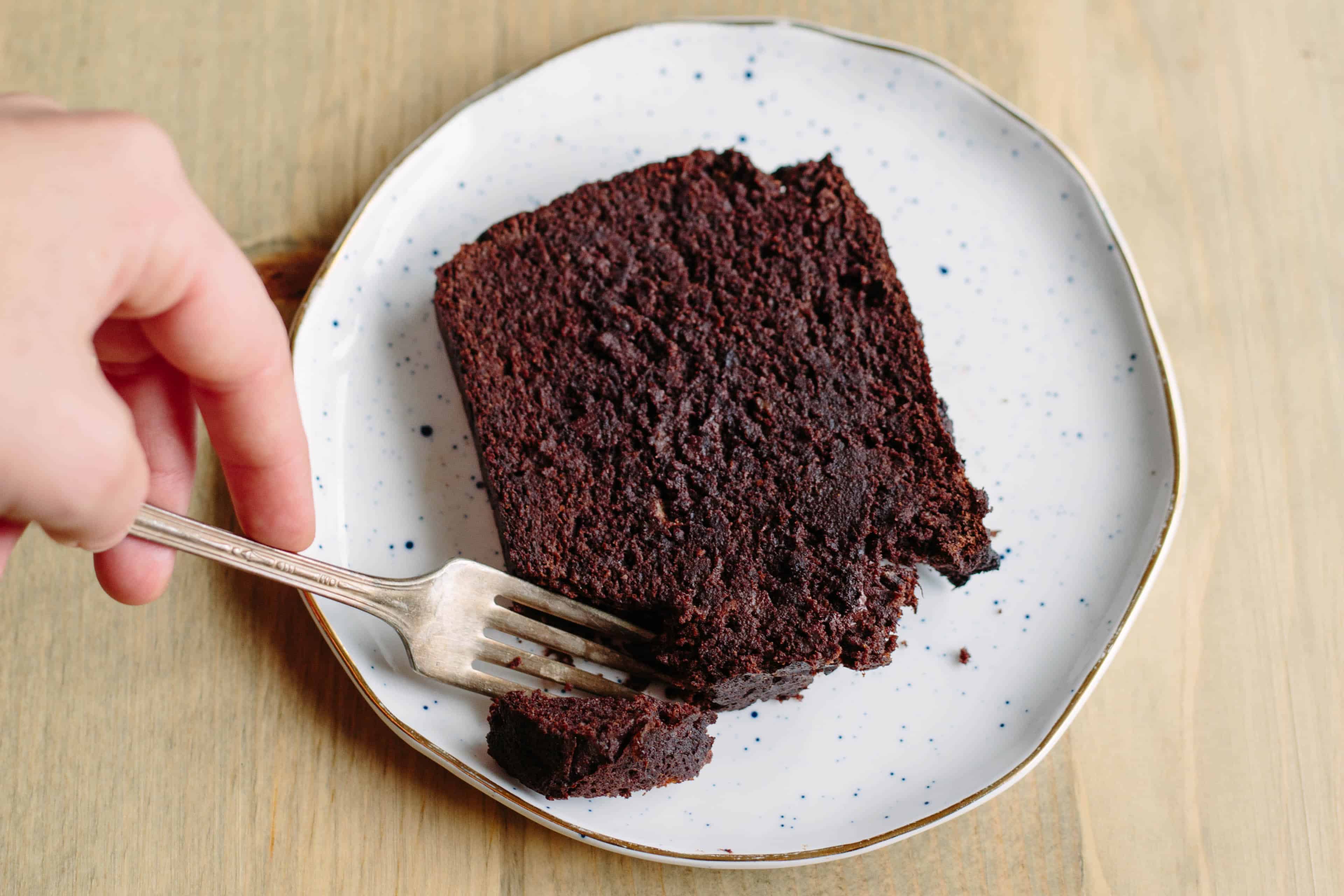 Top view of a slice of Paleo chocolate banana bread on a white dessert plate.