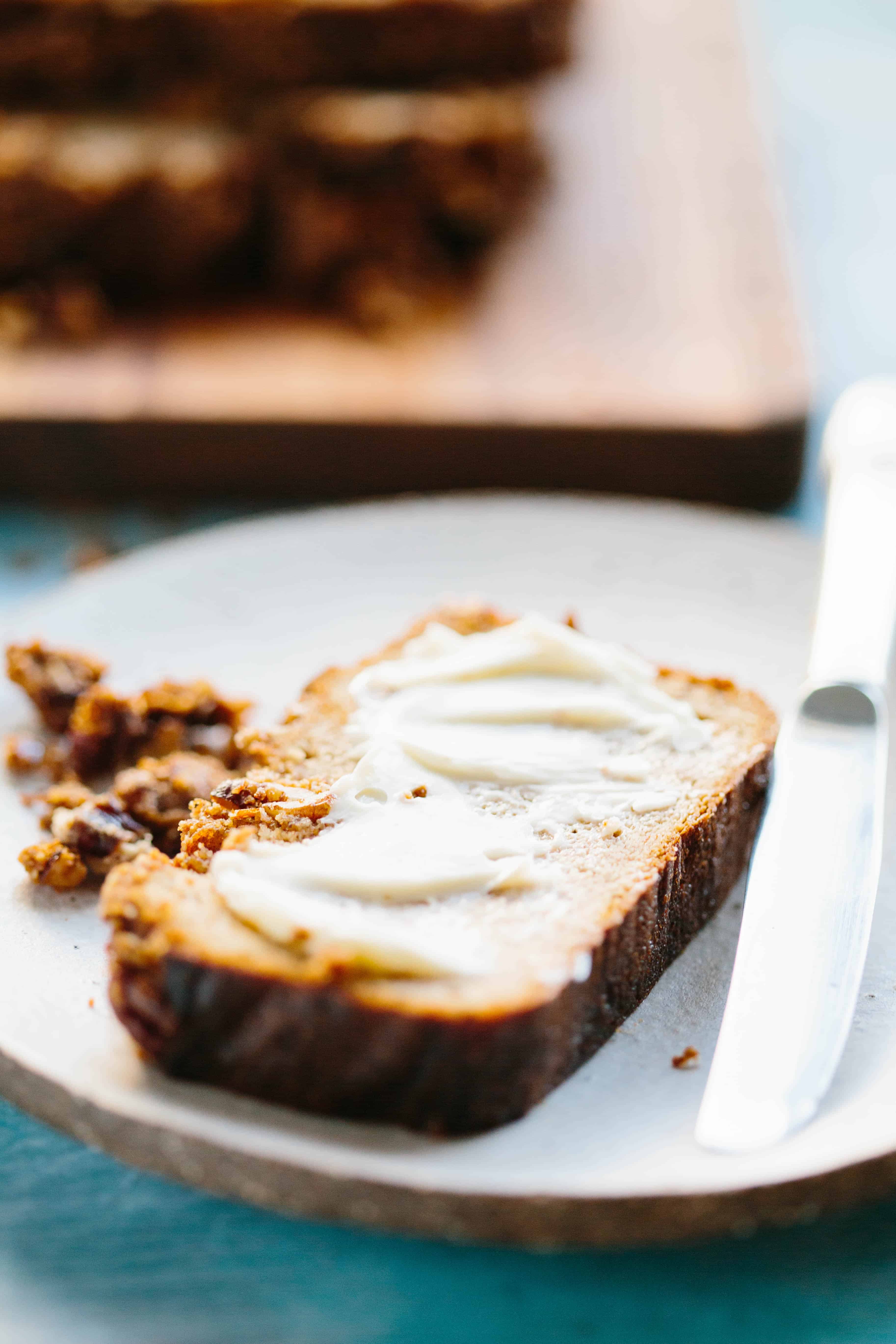 Close up of butter spread thickly on a slice of Paleo banana bread.