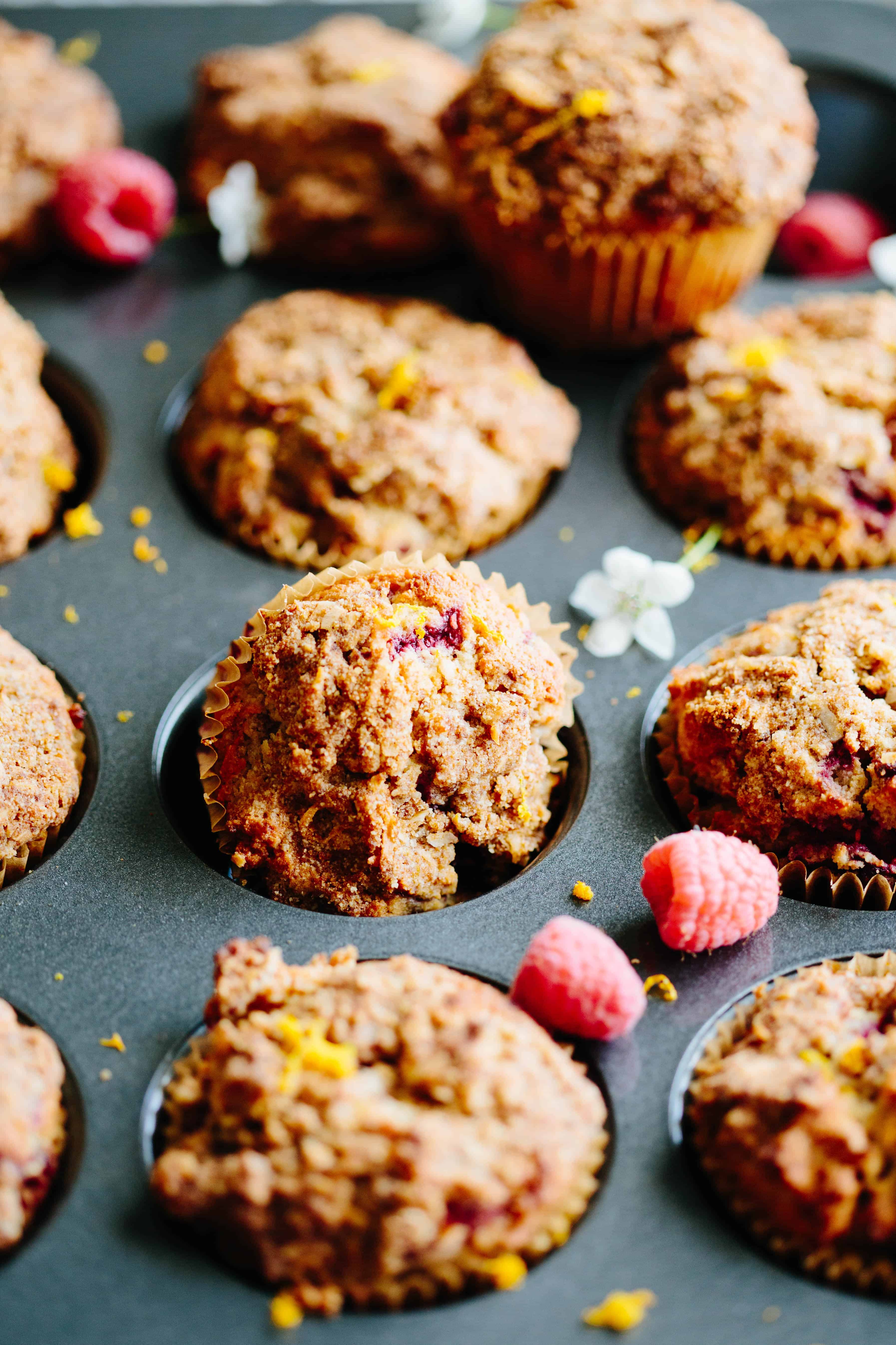 Close up of an orange raspberry Paleo muffin tipped in a muffin tin.