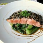 sesame crusted salmon on plate with bok choy and sweet soy drizzle
