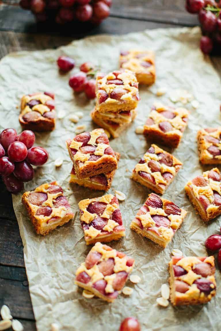 Sliced peanut butter grape bars on a sheet of parchment paper.
