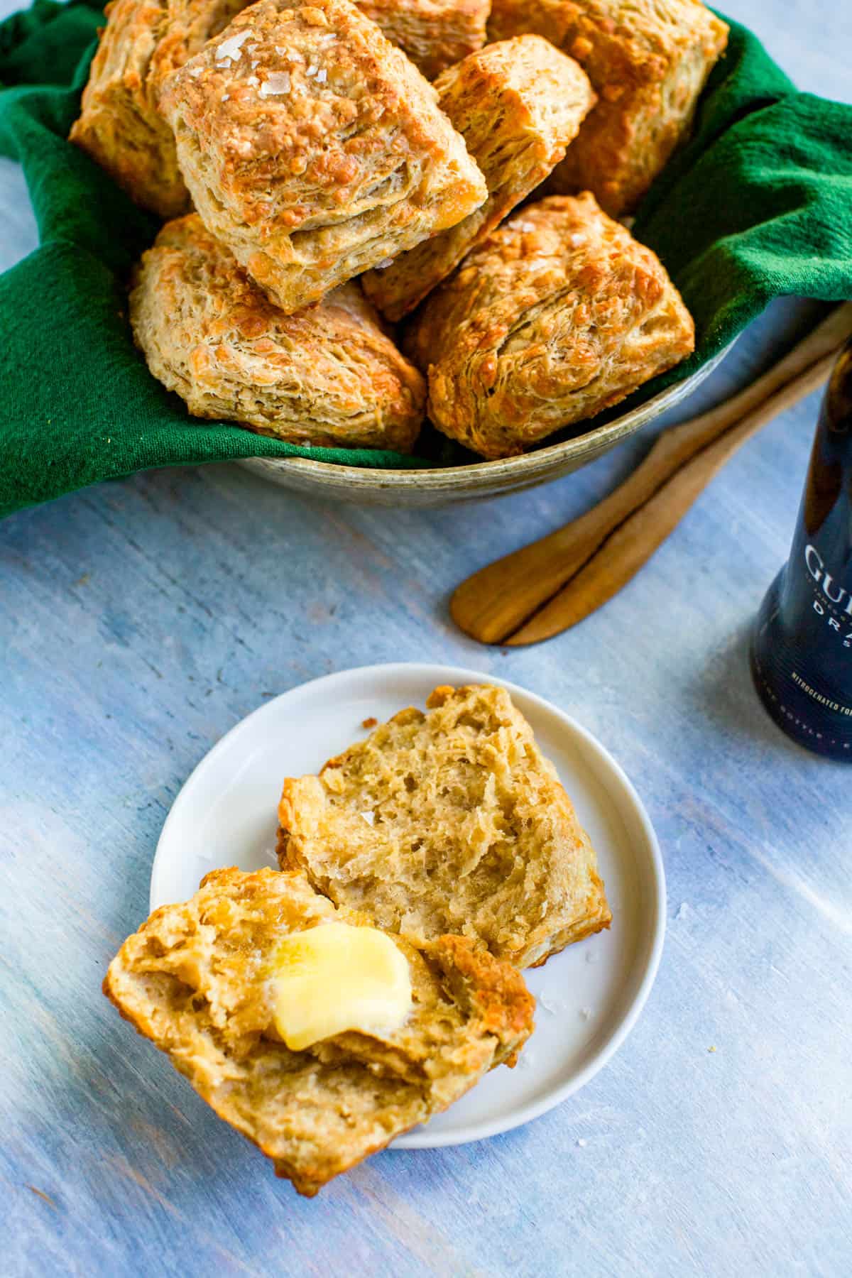 basket of biscuits with buttered biscuit on a plate