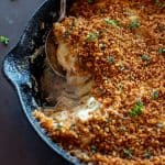 fennel onion gratin in a cast iron skillet with spoon and scoop taken out