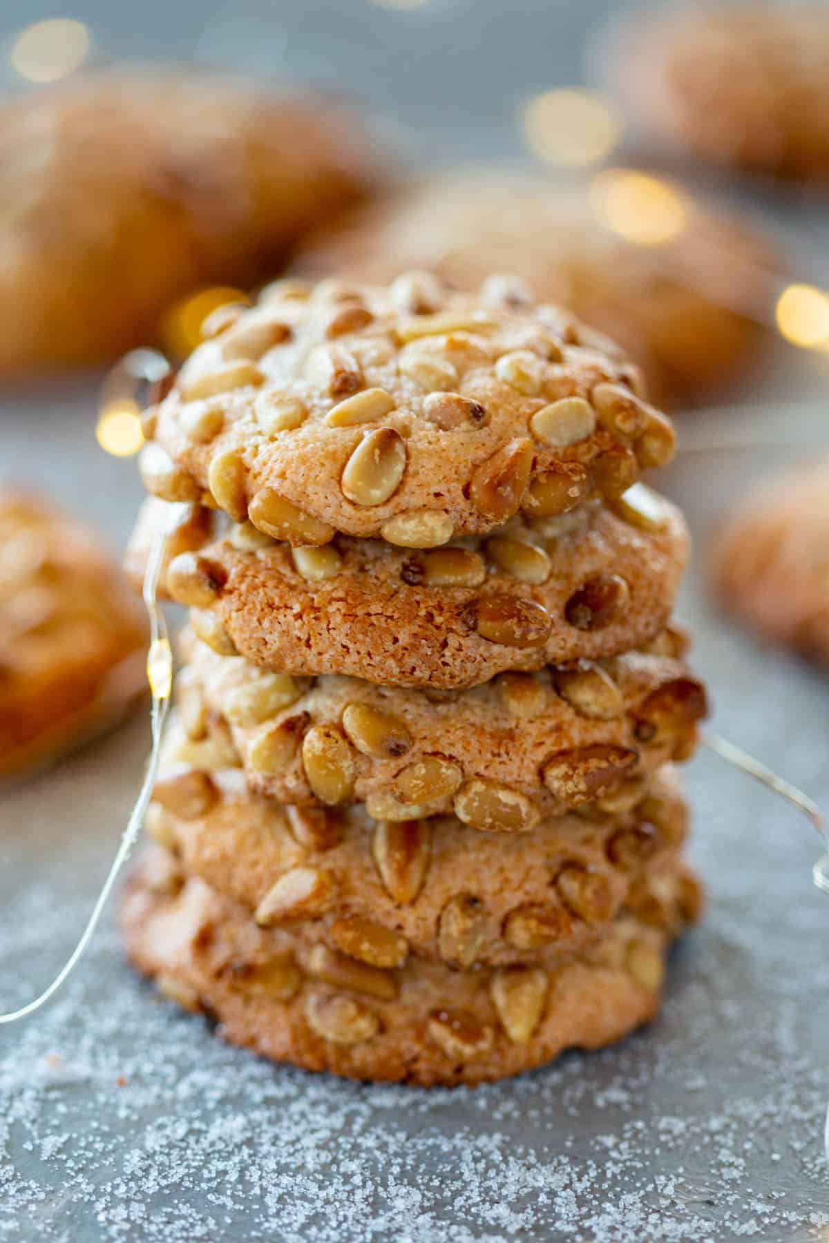 close up of stack of 5 Pignoli Cookies with fairy lights