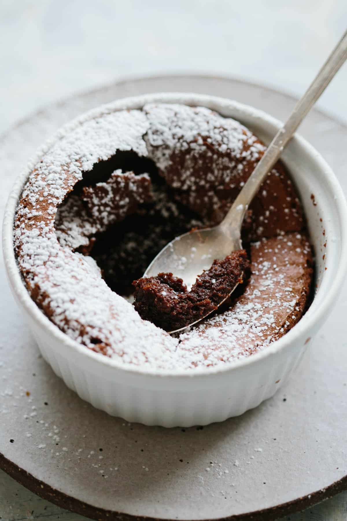 Close up of a bite of chocolate souffle on a teapsoon.