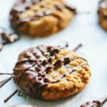 Closeup of a single peanut butter cookie that has been drizzled with chocolate.