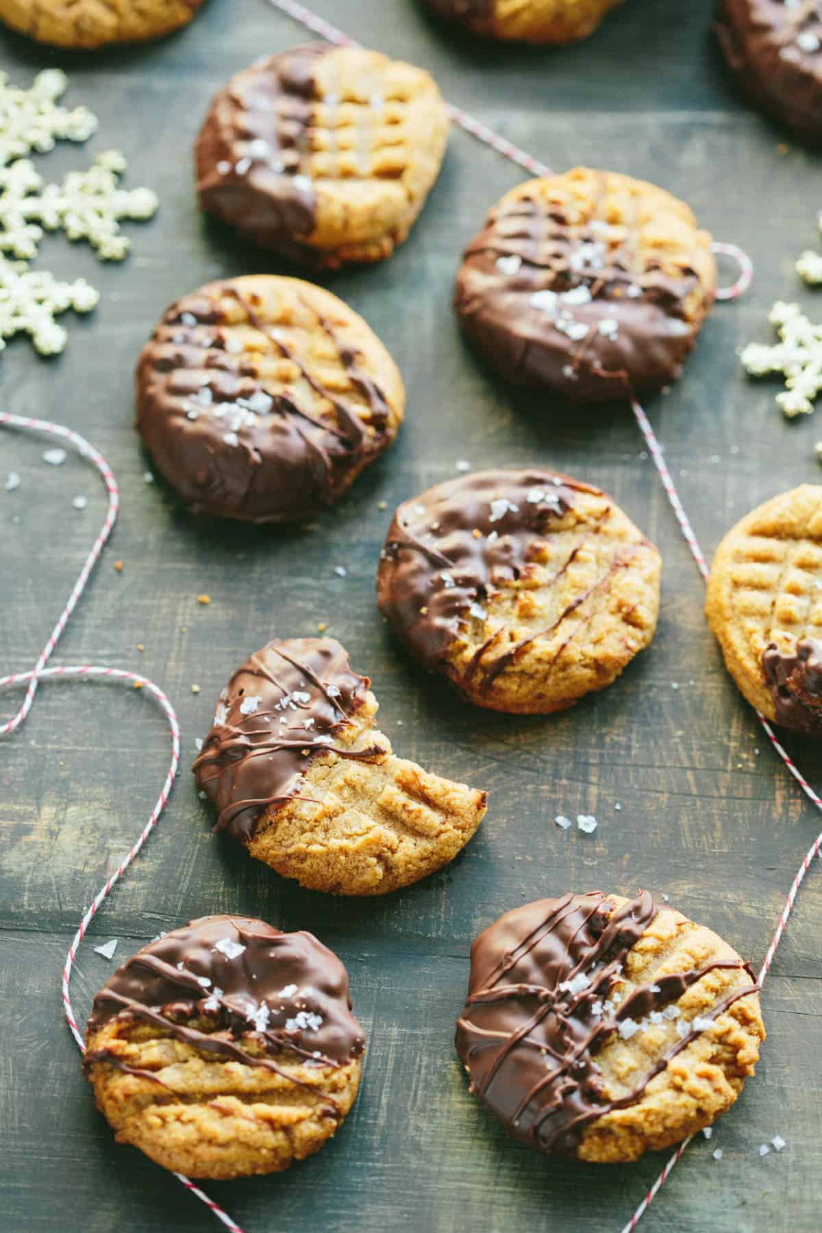 Top view of chocolate dipped peanut butter cookies, one of which has a bite from it.