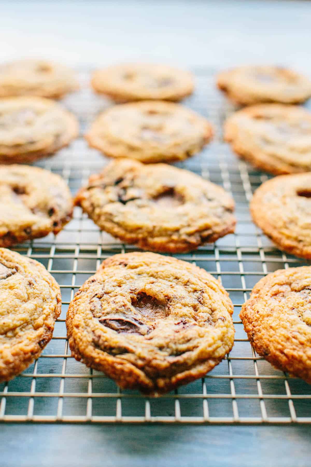 A close up of chocolate toffee chunk cookies cooling on a rack