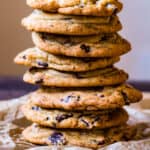 Close up side view vertical stack of chewy chocolate chunk cookies.
