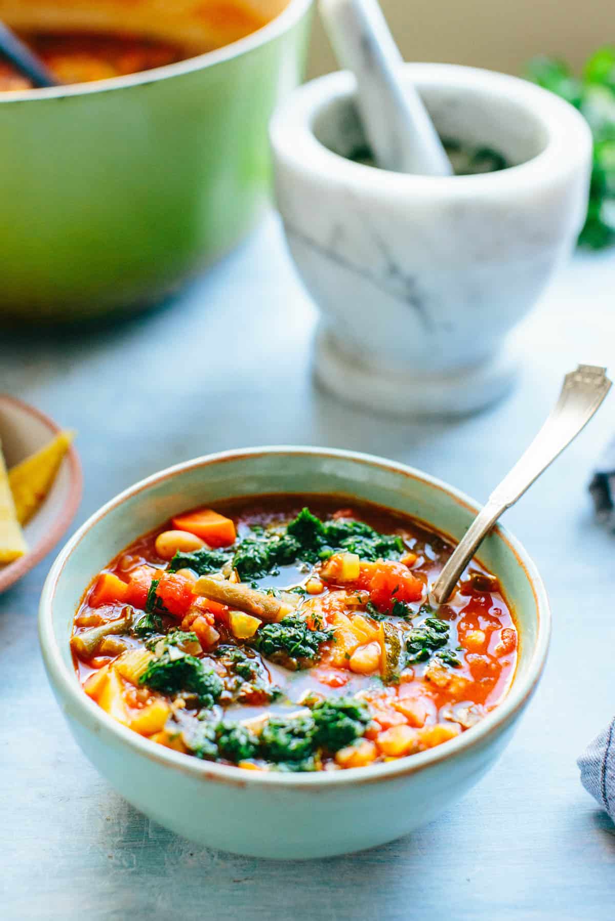 side view of a bowl of minestrone with Parsley Pistou on top
