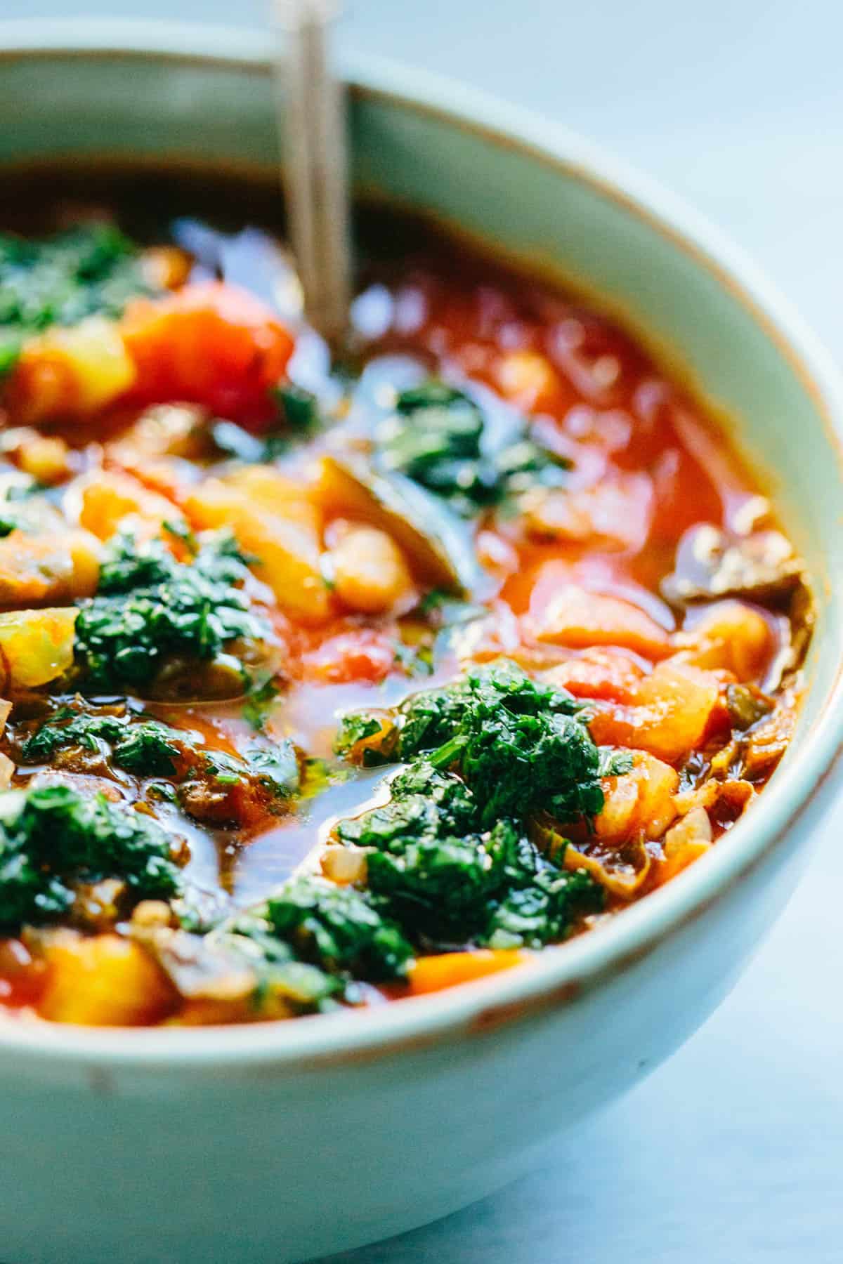 close up of vegetable minestrone soup with parsley pistou herb drizzle
