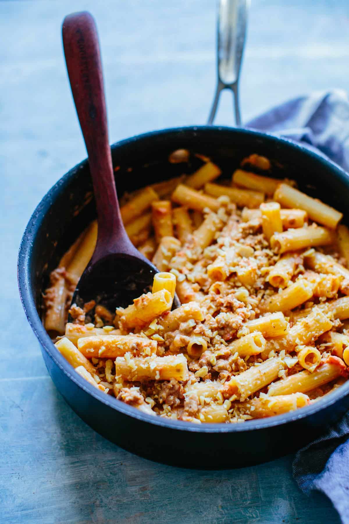 A pan with Rigatoni and a wooden spoon sticking out
