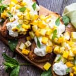 overhead shot of grilled zucchini bruschetta on a wood platter