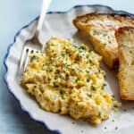 close up of soft scrambled eggs on a plate with a fork