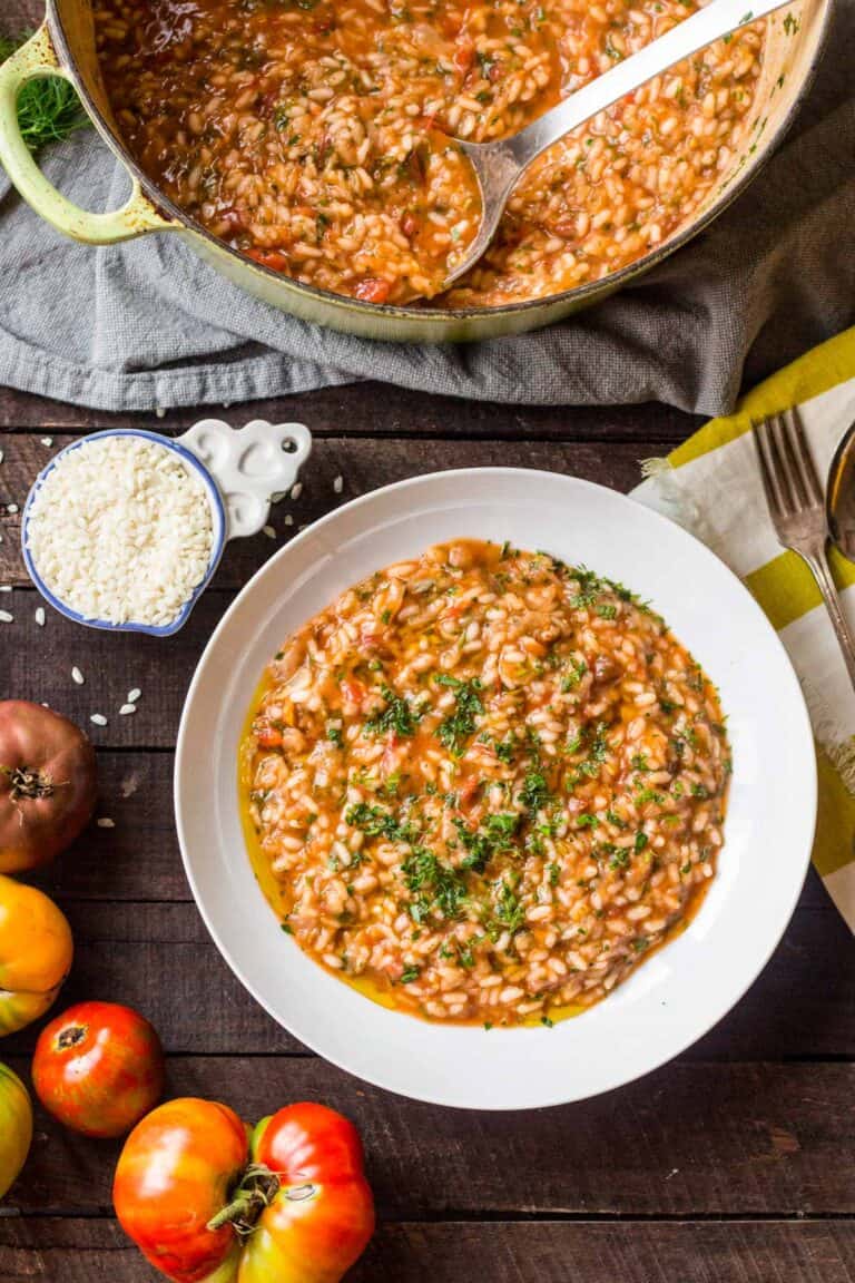 Top view of tomato fennel risotto in a white bowl.