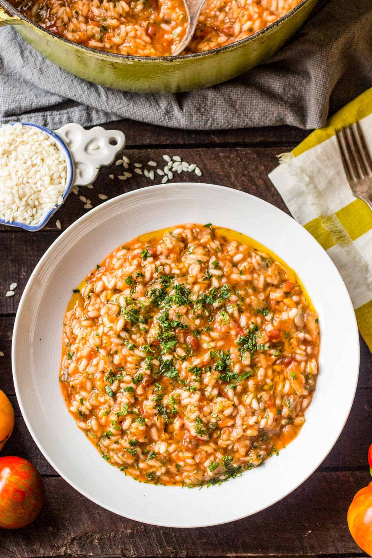 Close up overhead shot of tomato fennel risotto in a white bowl.