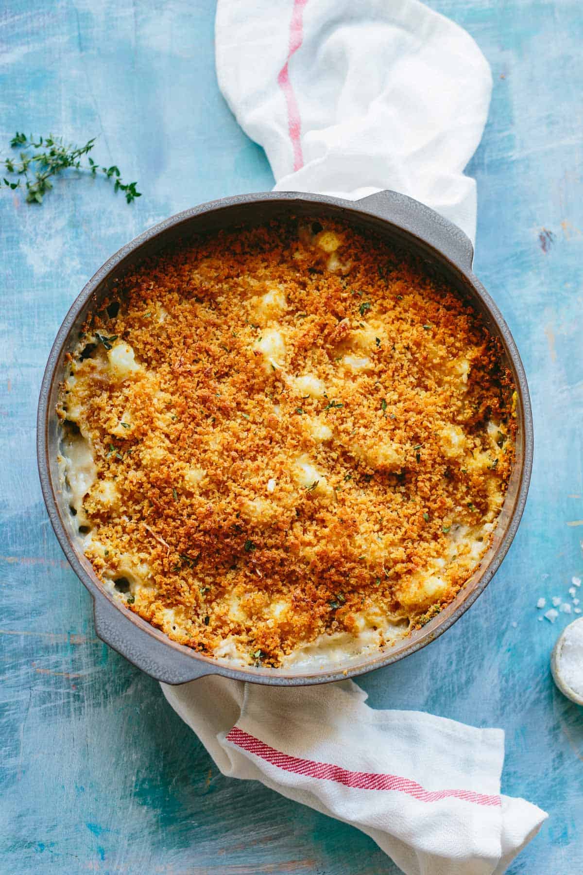 Birds eye view of a round casserole on a light blue surface.