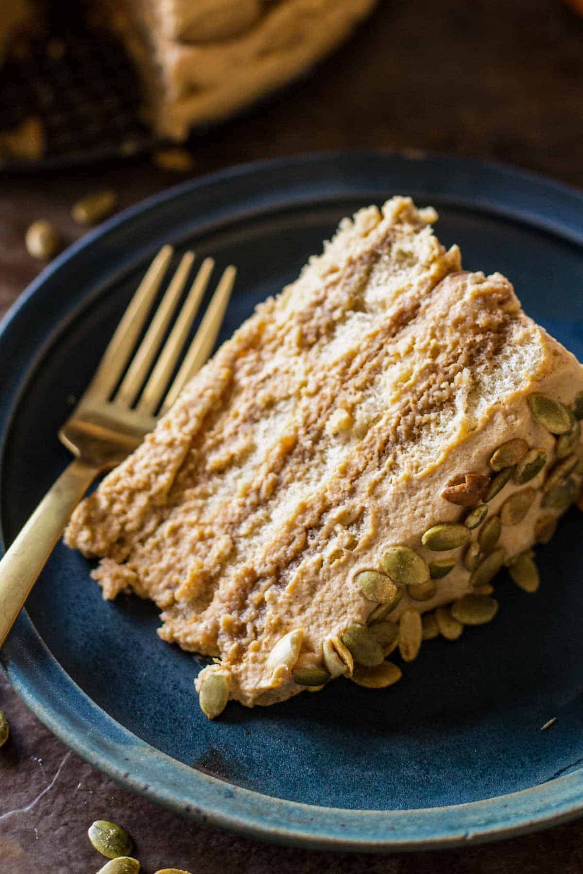 Close up of a slice of cake with a gold fork.