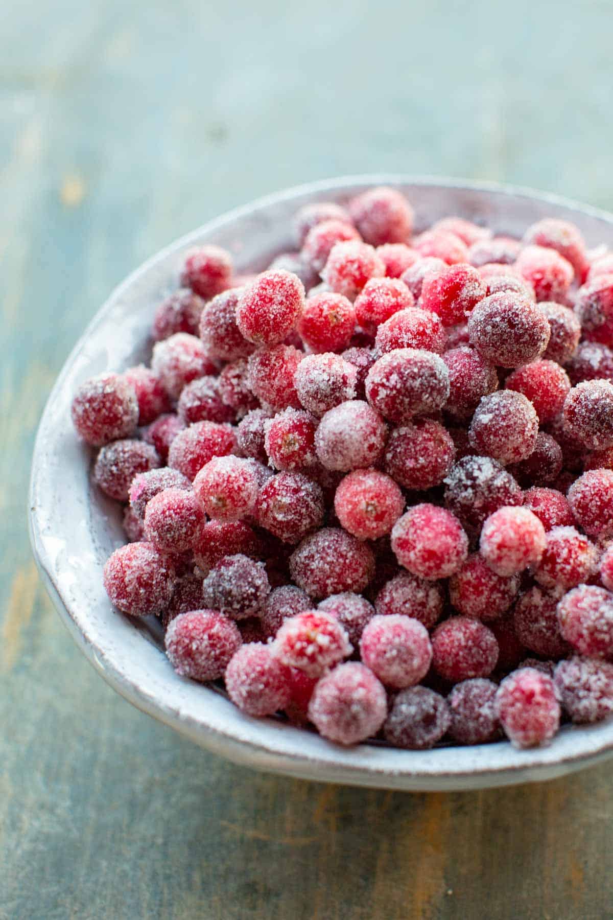 Side view of a bowl of sugared cranberries.