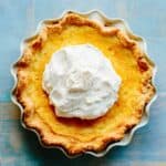 Top view of a pie with a big pile of whipped cream in the center.