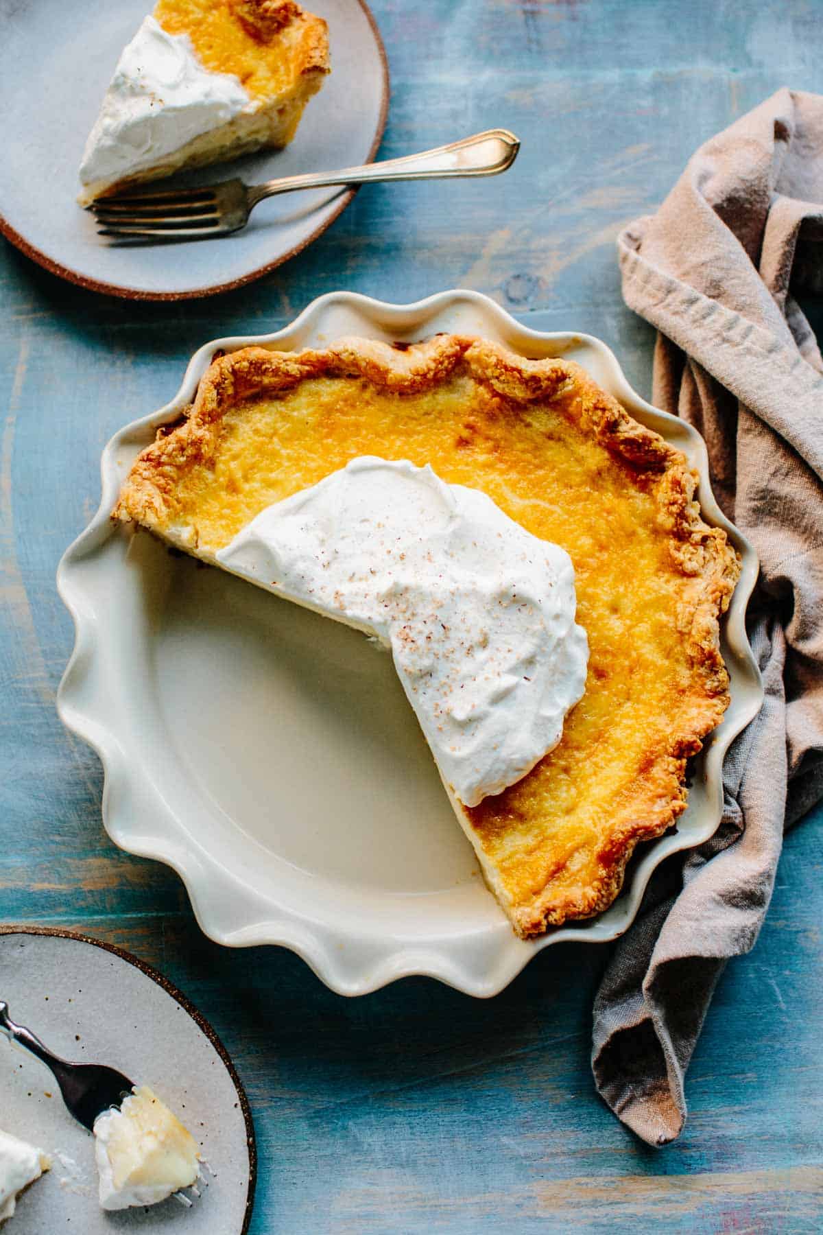 Brids eye view of a pie with several slices removed and a few plates around the perimeter.