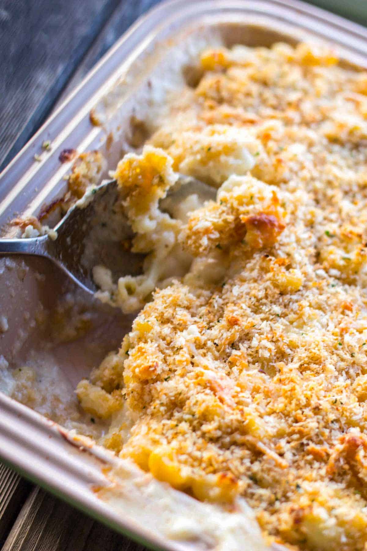 A casserole dish of macaroni and cheese with a serving spoon.