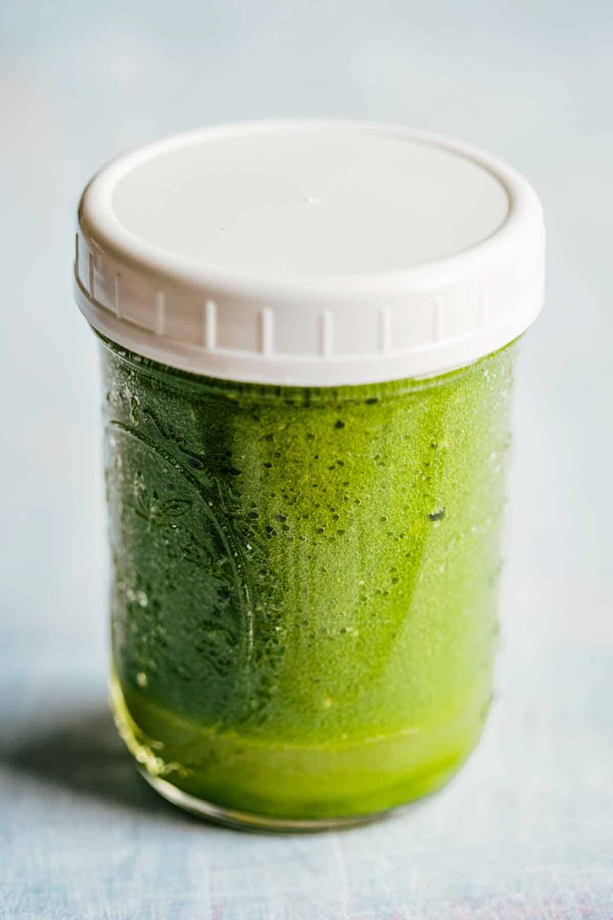 A mason jar of Jalapeño hot sauce with a white lid.