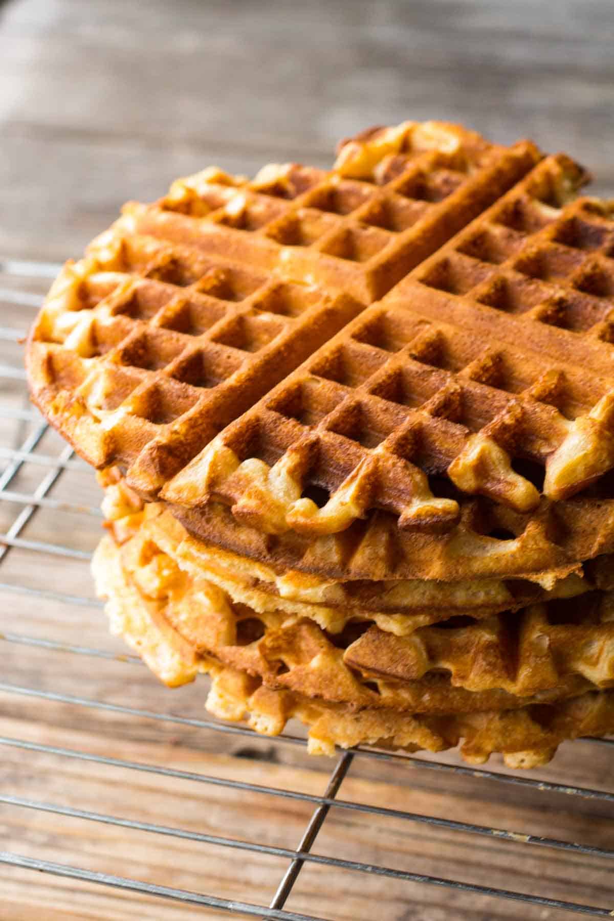 A stack of five waffles on a wire rack.