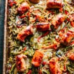 Overhead shot of a baking sheet with roasted Italian sausage, red and green peppers and onions.
