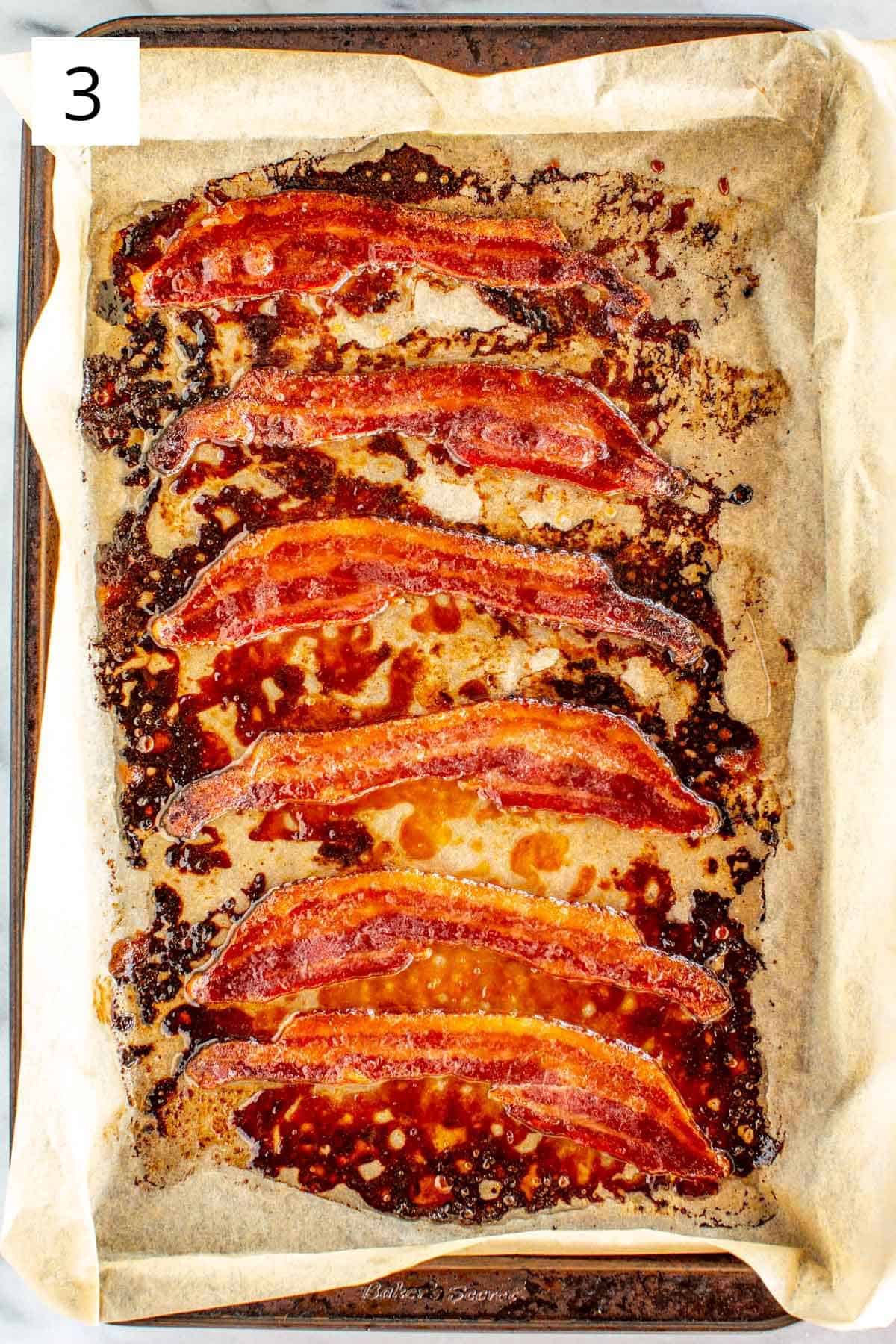 Brown sugar candied bacon on a parchment lined baking pan.