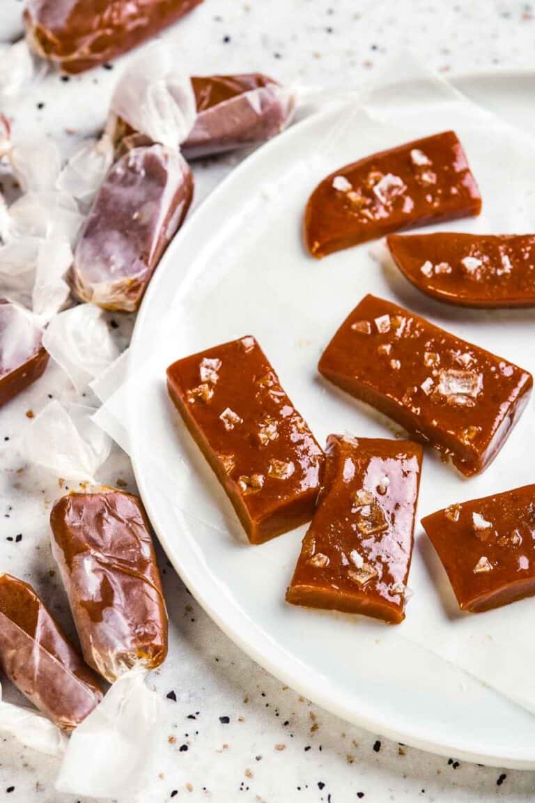 A plate of caramel candies with sea salt on a white plate.