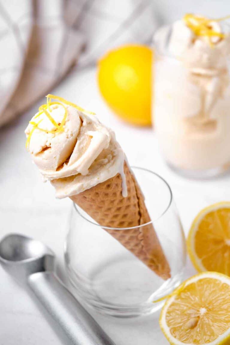 A glass holding an ice cream cone with lemon ice cream.