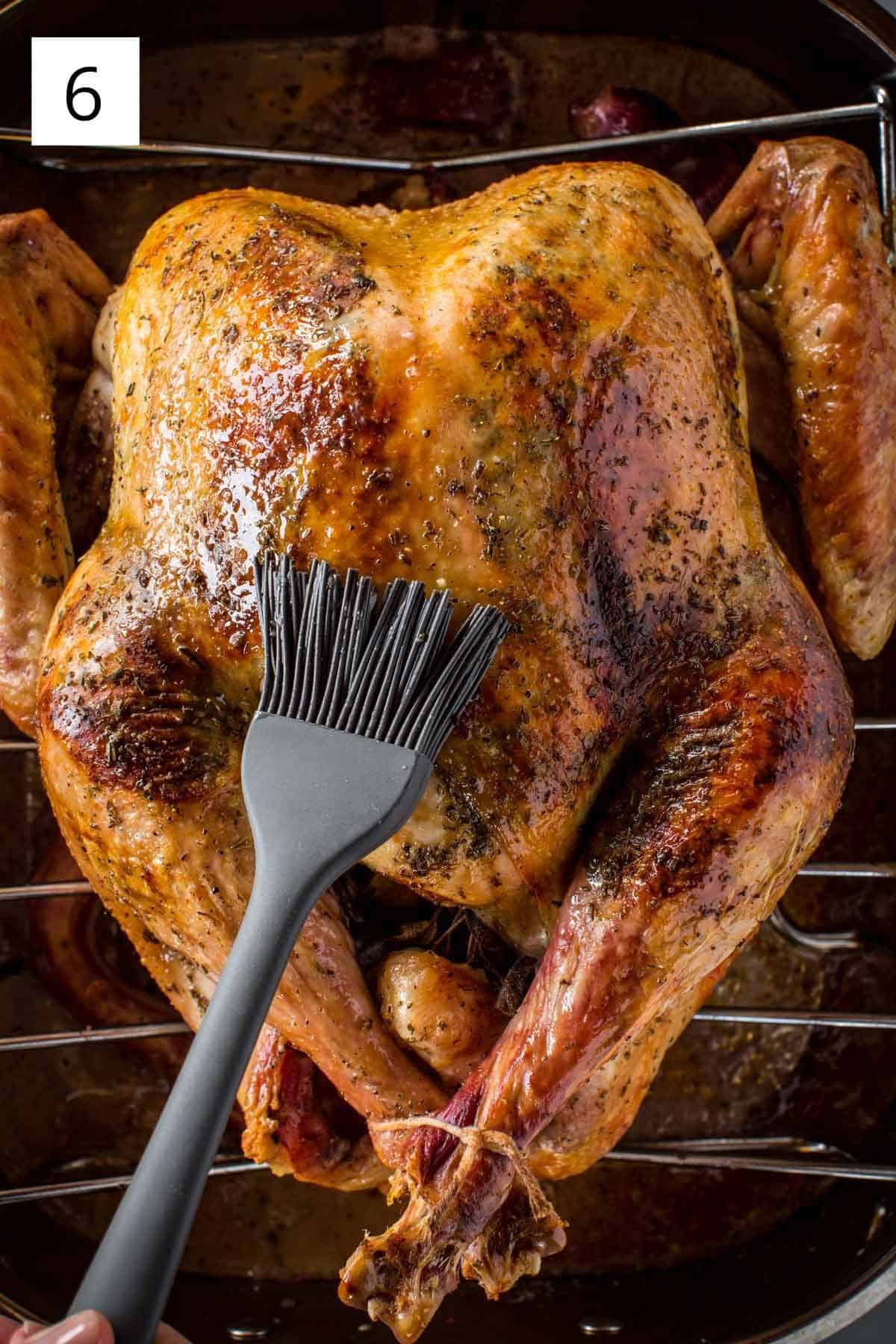 Basting the bird during cook time with pan juices using a silicone pastry brush.