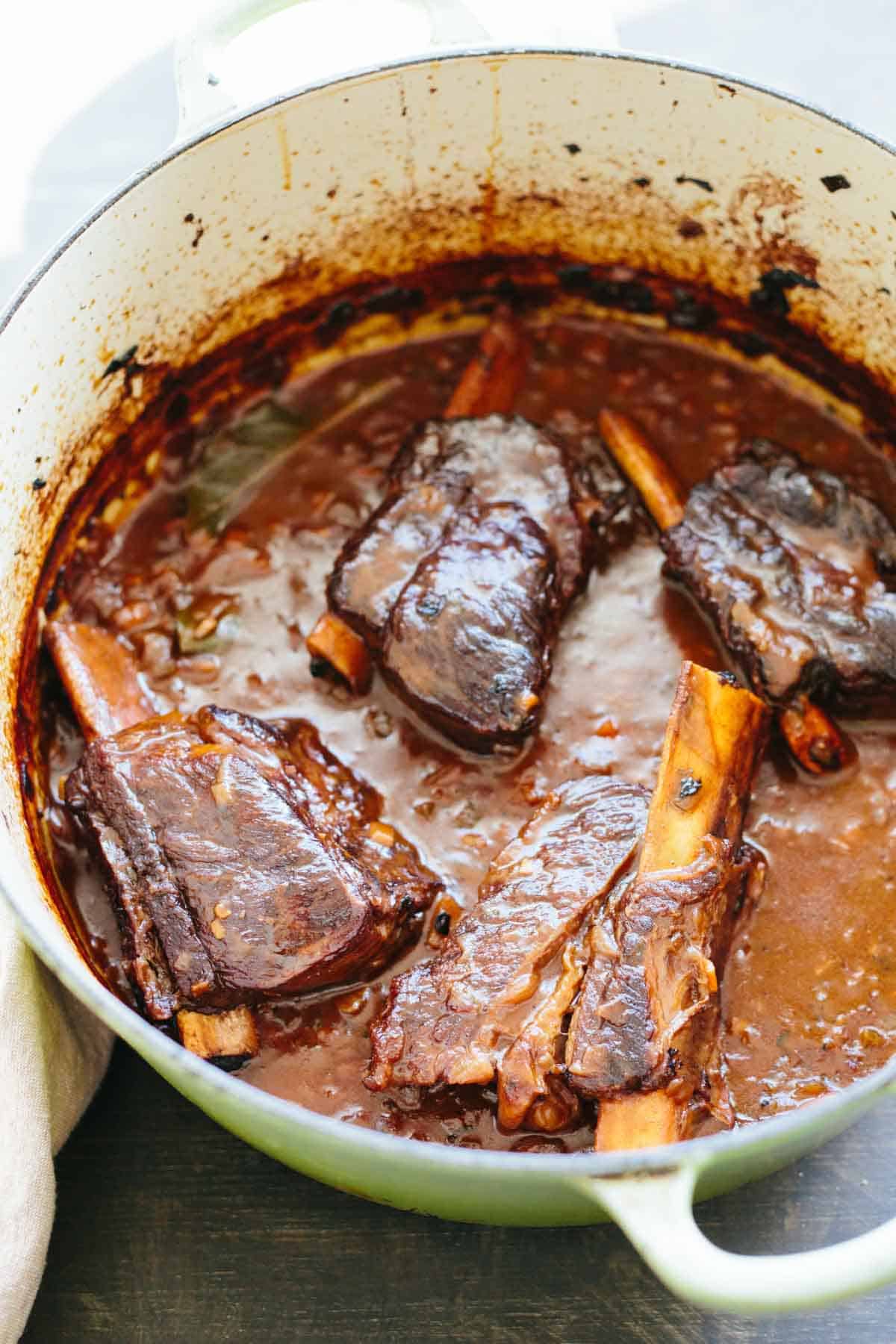 Braised beef short rib cooking in a Dutch oven.