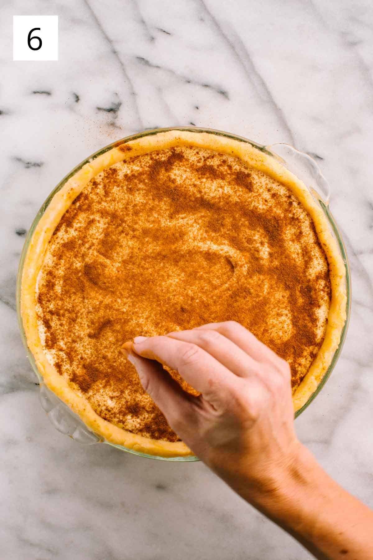 Sprinkling cinnamon on top of pre-baked dessert.