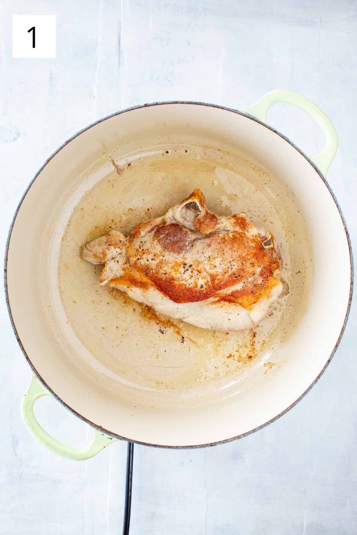 A pork loin browning in a Dutch oven.