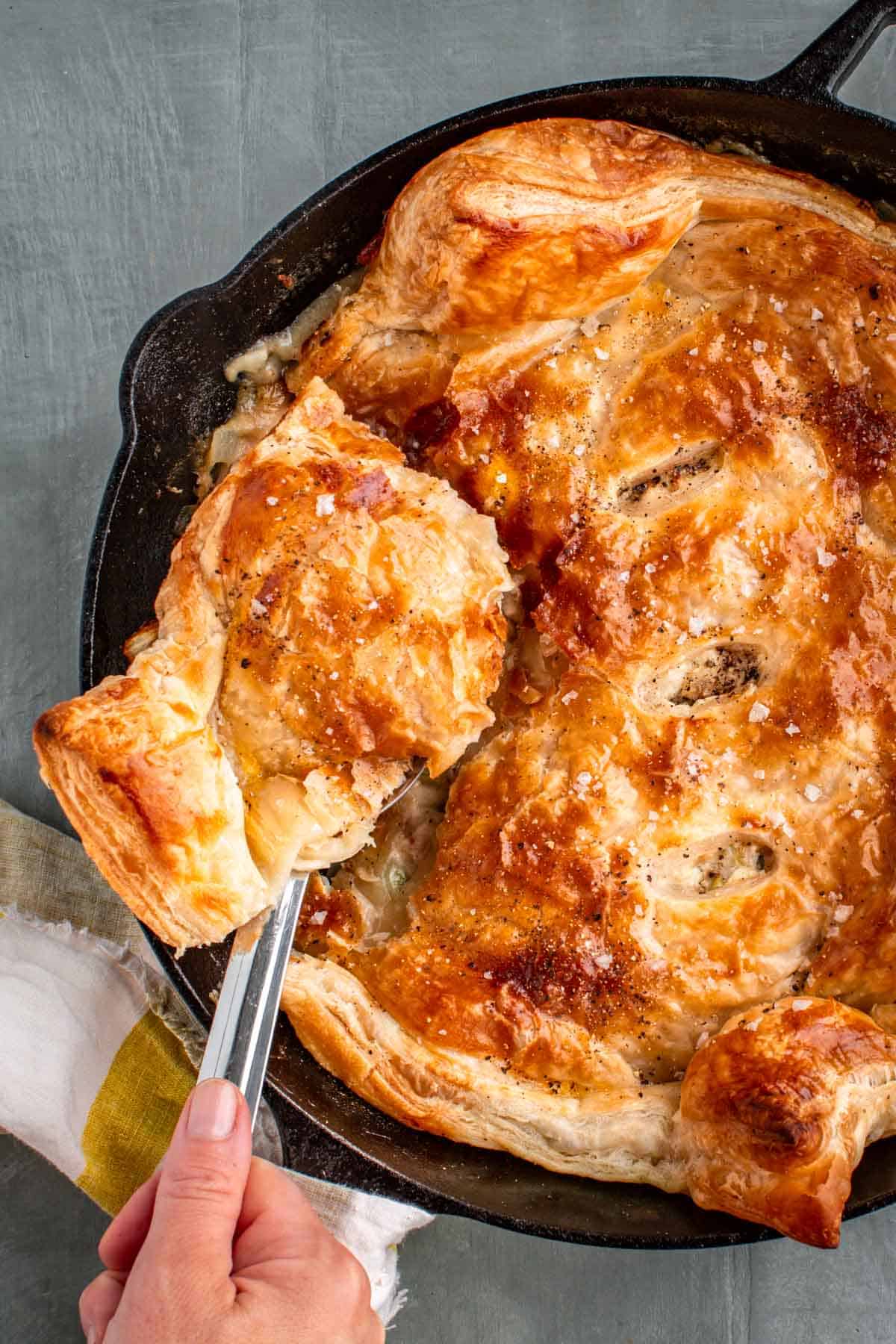 Scooping a a spoonful of turkey pot pie out of a skillet.