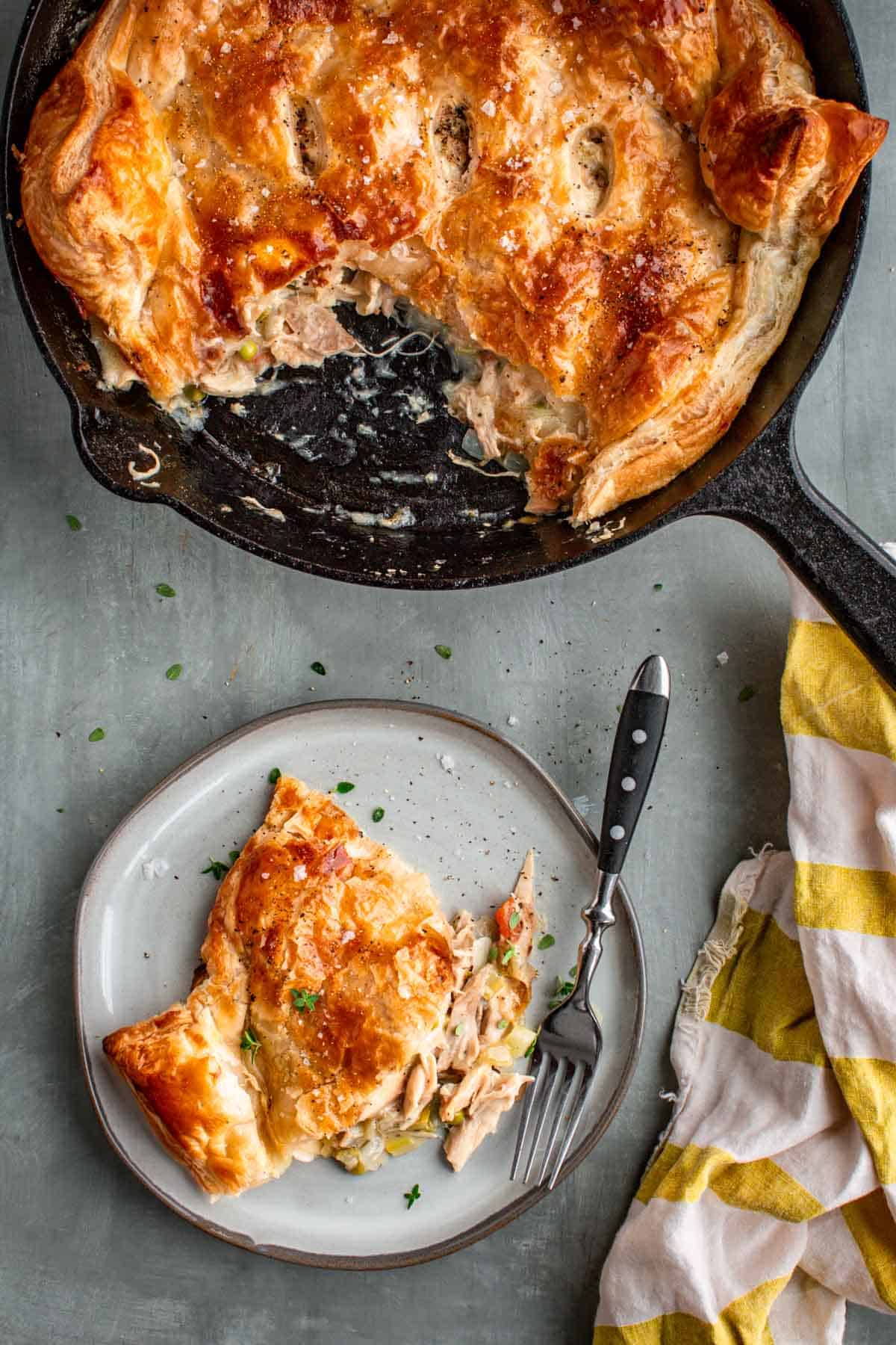 A skillet of turkey pot pie and a plate with a scoop of it.