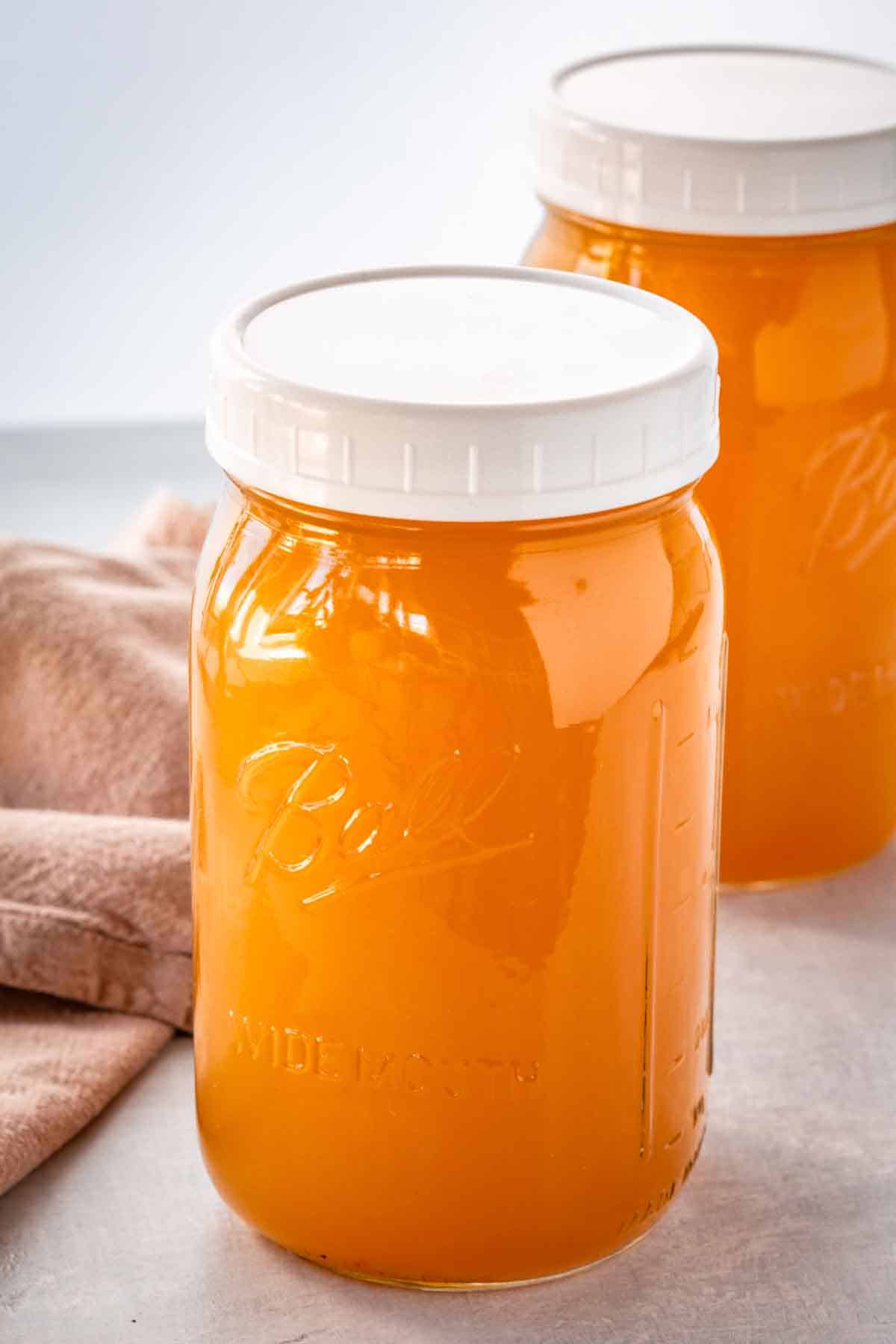 Two large mason jars filled with homemade turkey stock.