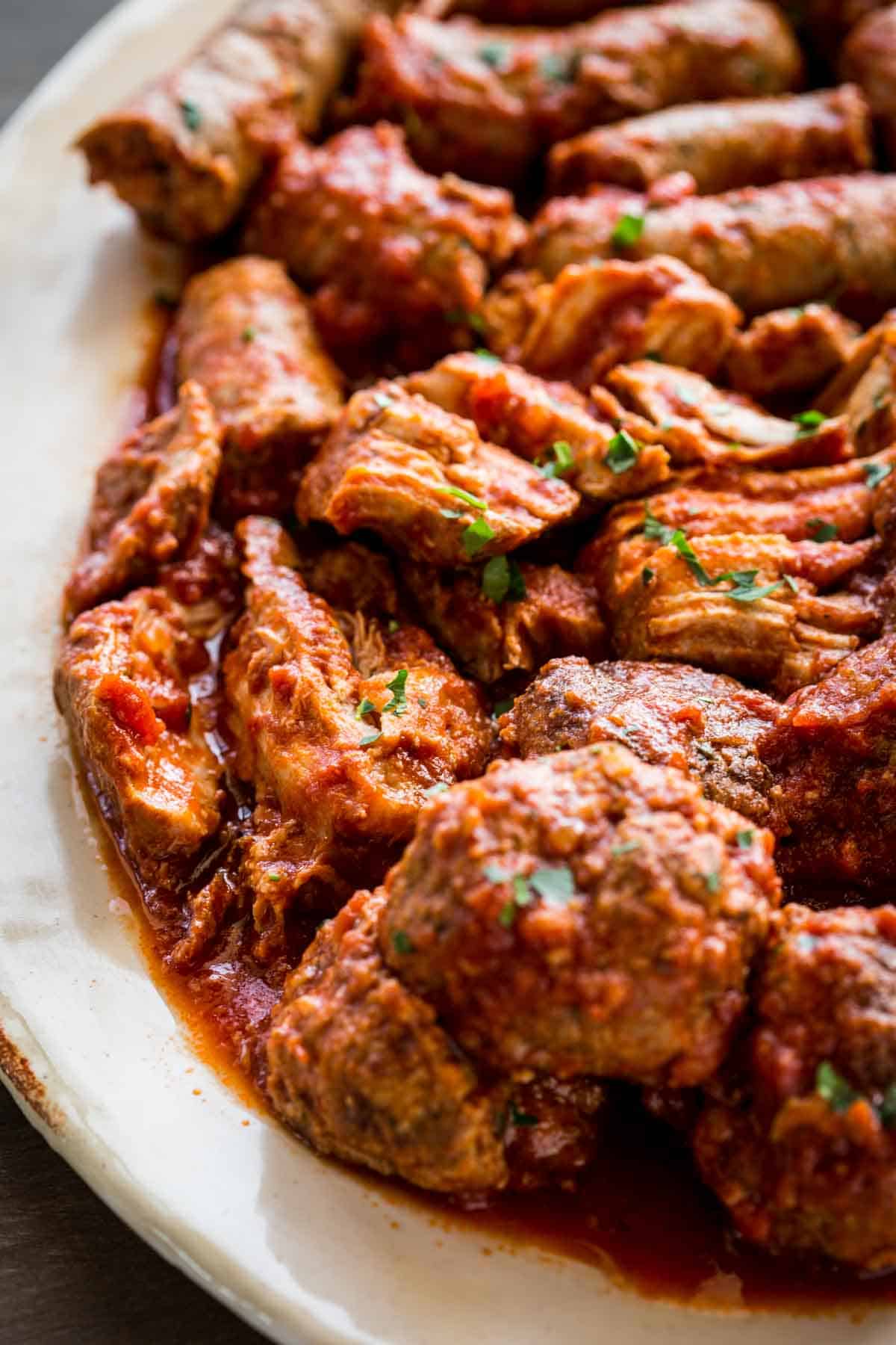 Close up of slow braised pork, sausage and meatballs from Italian Sunday gravy.