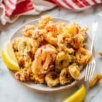 A plate of calamari fritti garnished with lemon.