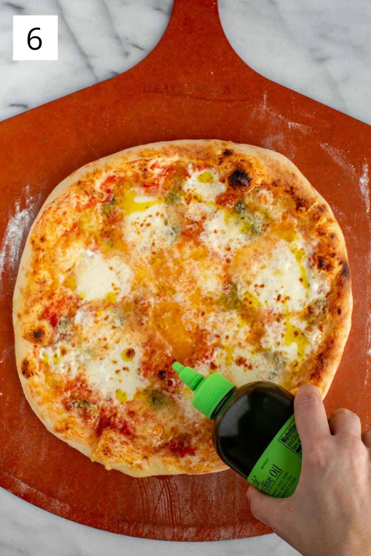 Adding quality olive oil to a fresh quattro formaggi pizza.